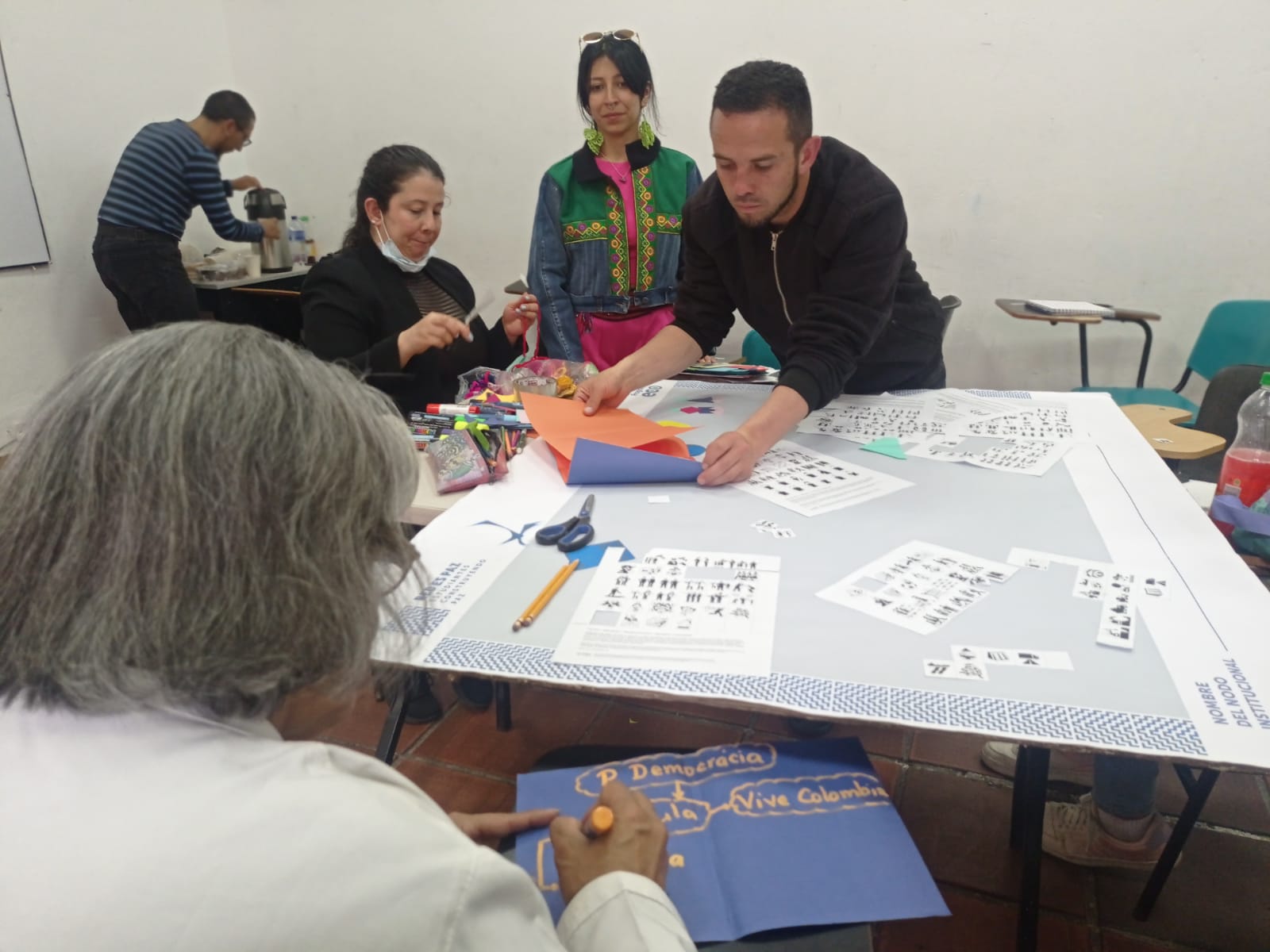 El colegio Tirso de Molina, de la localidad de la Candelaria, terminó una de sus jornadas con una rutina diferente: su equipo docente y directivo se reunió para recibir la visita del equipo de la Red de Instituciones Educativas que aportan al ecosistema de Paz y Reconciliación del Programa ECO. El objetivo: crear el nodo institucional que les permitirá conectarse con otros colegios y entidades que, como ellos, le apuestan a la paz.  ‘Aguapanelitas con Paz’ es un espacio diseñado por el programa ECO para docentes y directivos docentes, que invita al diálogo, la cercanía y el trabajo en red. Al calor de un agua de panela, las comunidades educativas identifican las iniciativas sobre paz que existen en sus colegios y así fortalecen sus experiencias pedagógicas, al tiempo que se conectan con nodos locales y distritales.   Los nodos son espacios de trabajo donde confluyen diferentes comunidades educativas, que les permiten trabajar en red y fortalecer la apuesta de construir escuelas como territorios de paz.  “Ser parte del Programa ECO es un proceso muy significativo. El Distrito siempre se piensa desde lo público y eso genera división, por eso, espacios como estos desdibujan esas líneas imaginarias y eso es muy valioso, especialmente cuando hablamos de paz, porque de eso se trata la paz, ¿no?, de construir lazos, de encontrarnos en la diferencia”, comenta Andrés Díaz, docente de ciencias sociales del colegio Tirso de Molina.  Como el profe Andrés, 233 docentes y directivos de 11 colegios privados de la ciudad han aceptado la invitación de tomarse una Aguapanelita con Paz. Gracias a este espacio, el colegio Tirso de Molina empieza a tener resultados significativos luego de identificar y poner bajo una misma sombrilla las diferentes experiencias pedagógicas que en su colegio abordan el tema de la paz.   Imagen dentro del texto 1  ‘Un nuevo sol en búsqueda de la verdad humanamente justa’ es el nombre elegido por este grupo de docentes para su nodo institucional que ya está listo para unirse a alguno de los nodos locales