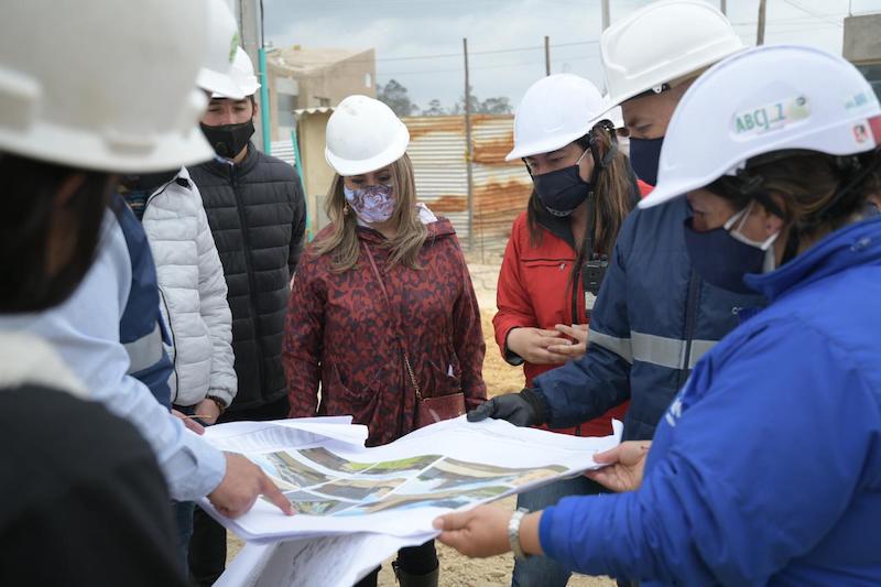 La secretaria de educación revisando planos