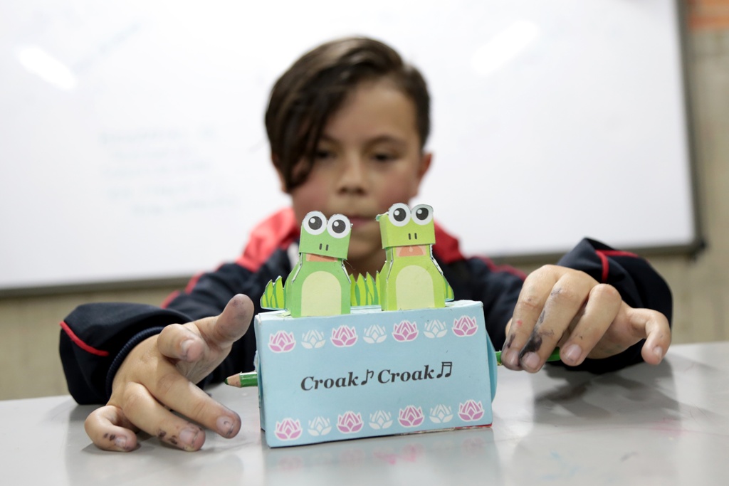 Un niño con un juguete de sapitos
