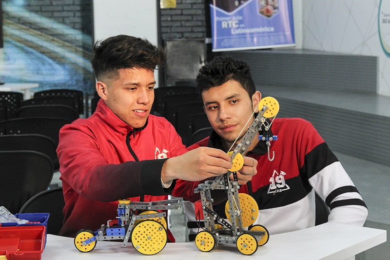 Dos estudiantes armando un robot