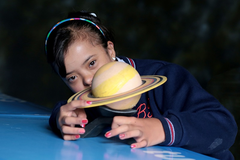 Niña observando un planeta