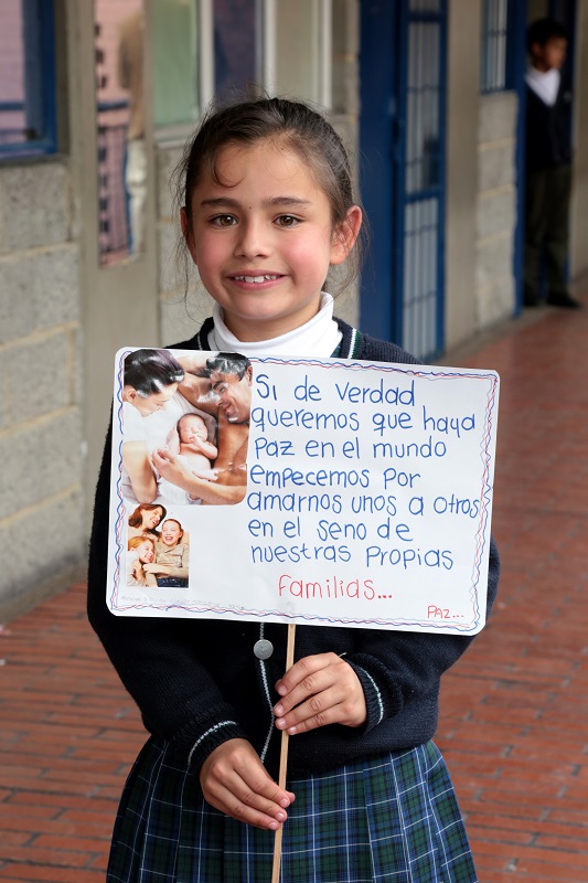 Niña sosteniendo un aviso