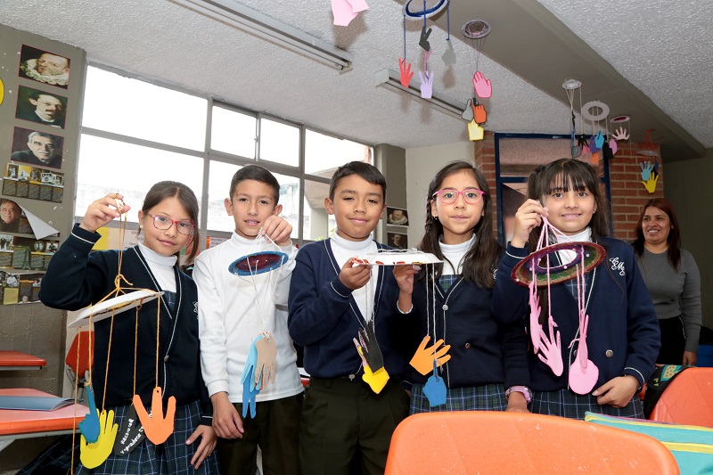 Niños sosteniendo manualidades 