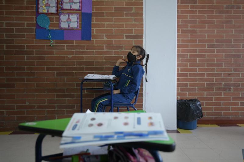 Estudiante sentada con un tapabocas